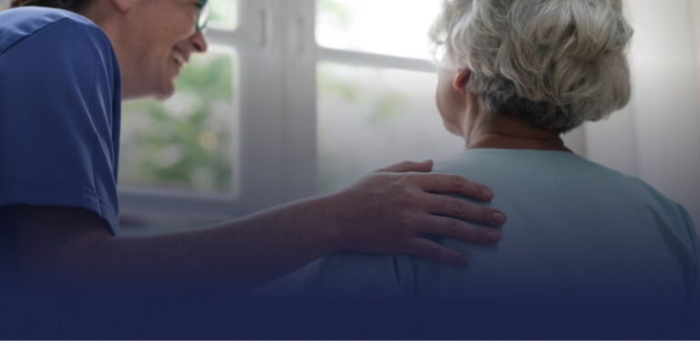 Imagen de enfermera asistiendo a una persona mayor con una sonrisa